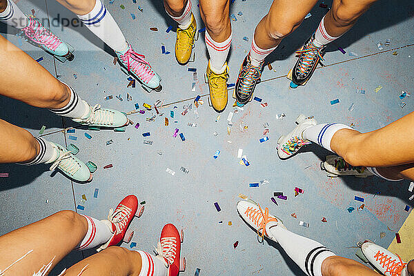Legs of women wearing roller skates celebrating together
