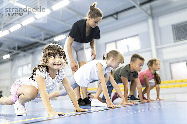 Lehrer säumen Schüler an der Startposition im Schulsportplatz