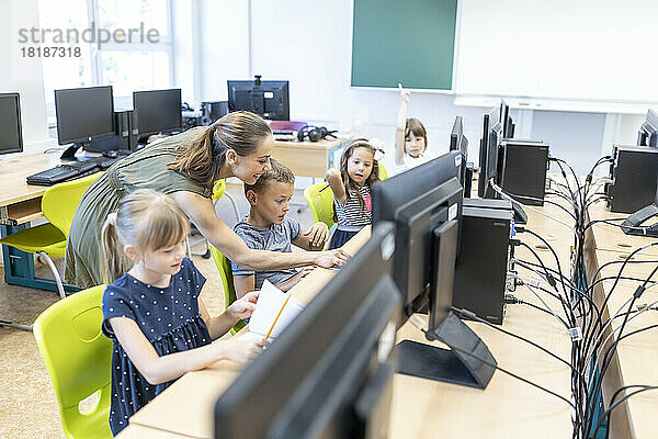 Lehrer hilft Schülern beim Lernen durch E-Learning in der Schule