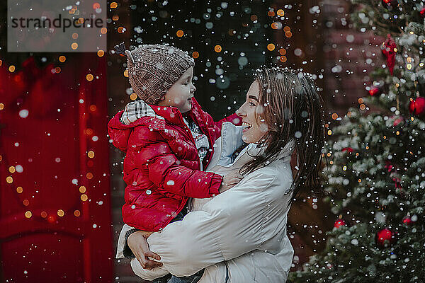 Fröhliche Mutter mit Sohn genießt den Schnee