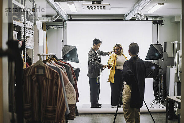 Männliches Design professionelle Messung Jacke von Mode-Modell während Foto-Shooting im Studio