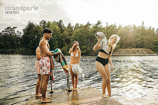 Männliche und weibliche Freunde genießen am See im Urlaub