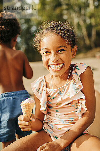 Porträt eines glücklichen Mädchens mit einem Eis in der Hand an einem sonnigen Tag