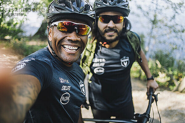 Glücklicher männlicher Radfahrer  der ein Selfie mit einem Freund macht