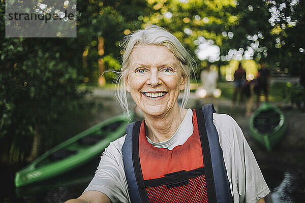 Porträt einer glücklichen älteren Frau mit Schwimmweste
