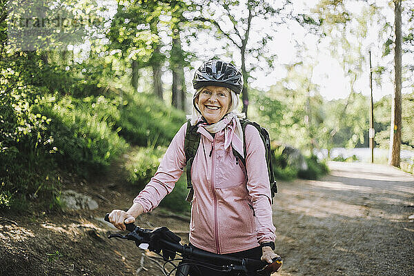 Porträt einer älteren Frau mit Fahrrad auf dem Fußweg