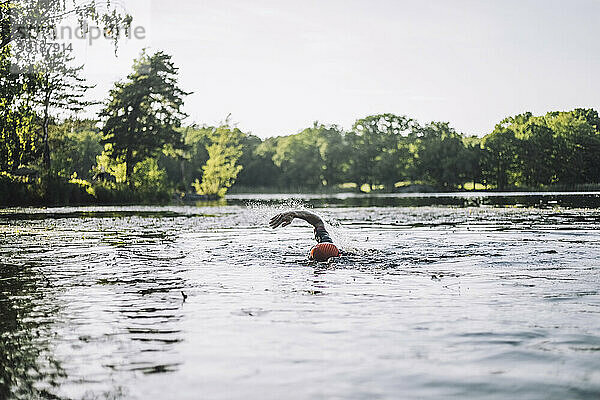 Älterer Mann übt Freistilschwimmen im See