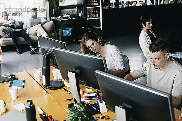 Weibliche und männliche Programmierer  die während ihrer Arbeit in einem Start-up-Unternehmen am Computer programmieren