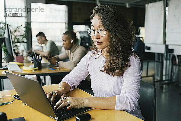 Weibliche Computerprogrammiererin programmiert am Laptop am Schreibtisch in einem Start-up-Unternehmen