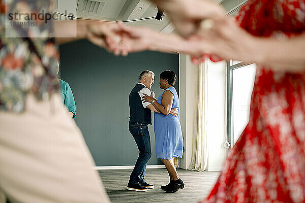 In voller Länge von multirassischen älteren Paar übt Tanz in der Klasse