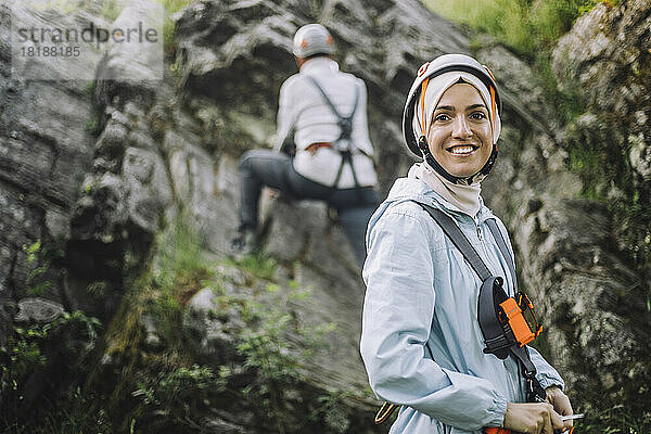 Porträt einer lächelnden Frau mit Helm beim Klettern