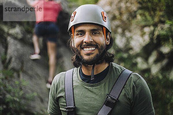 Porträt eines lächelnden Mannes mit Sporthelm beim Klettern