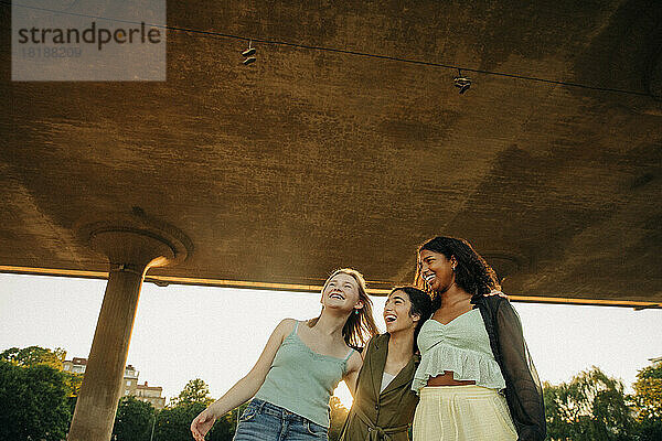 Fröhliche Freundinnen im Teenageralter  die sich unter einer Brücke vergnügen