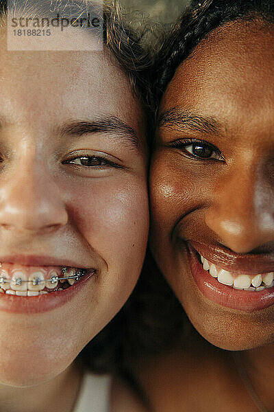 Glückliches Teenager-Mädchen mit Zahnspange von einer Freundin