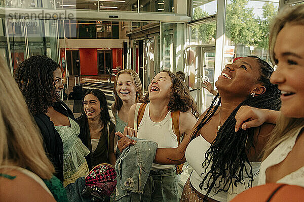 Teenager-Mädchen lachen  während sie sich in einem Einkaufszentrum vergnügen