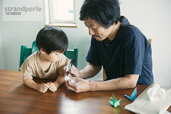 Japanisches Kind spielt zu Hause mit seinem Vater