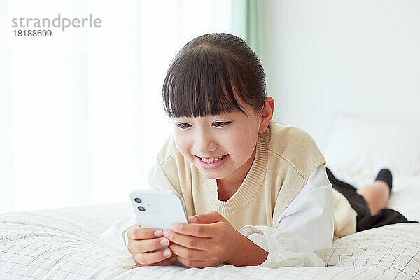 Japanisches Kind benutzt Smartphone zu Hause
