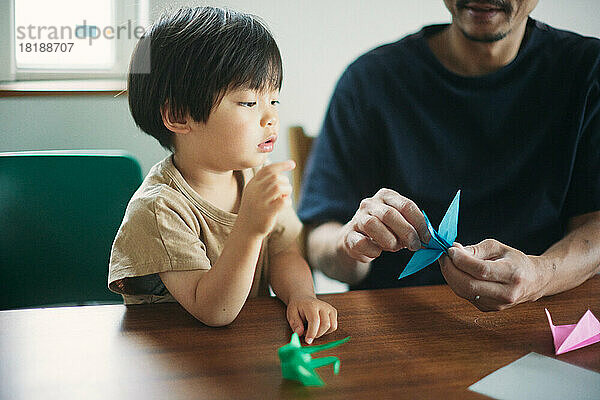 Japanisches Kind spielt zu Hause mit seinem Vater