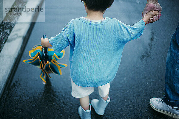 Japanese kid playing outside on a rainy day