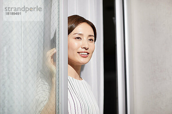 Japanische Frau schaut aus dem Fenster