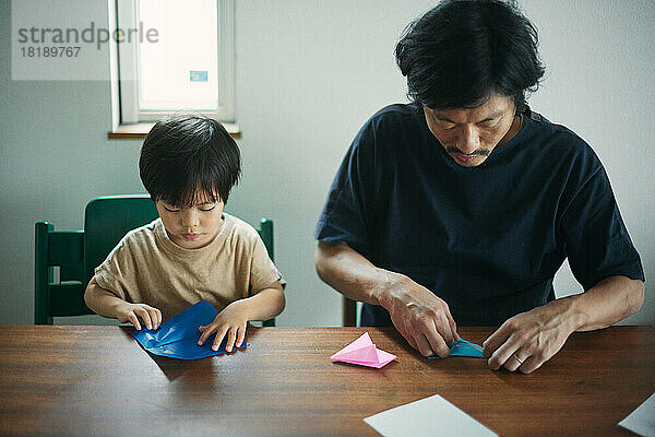 Japanisches Kind spielt zu Hause mit seinem Vater