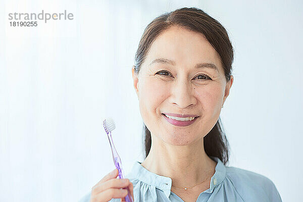Japanische ältere Frau beim Zähneputzen