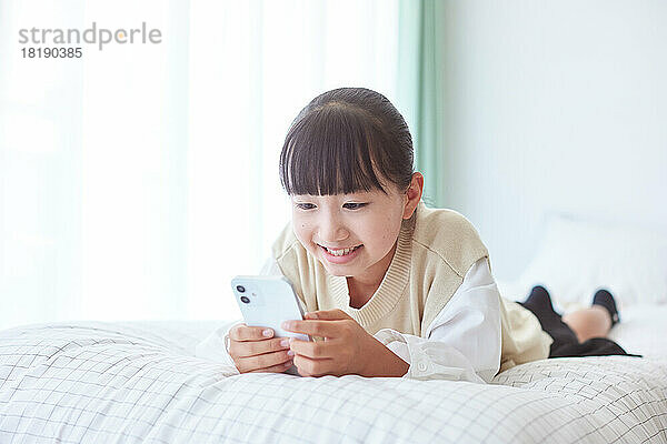 Japanisches Kind benutzt Smartphone zu Hause