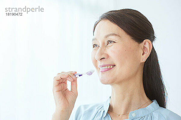 Japanische ältere Frau beim Zähneputzen
