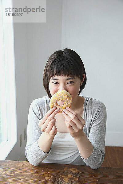Junge Japanerin isst einen Donut