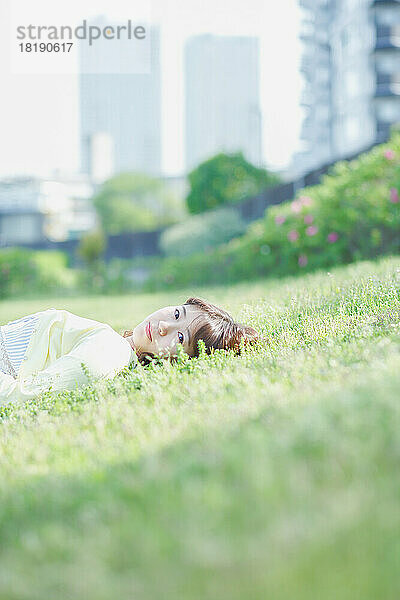 Japanerin entspannt sich im Gras