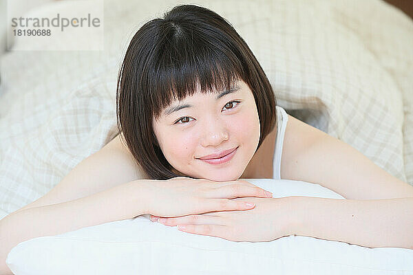 Young Japanese woman relaxing in bed