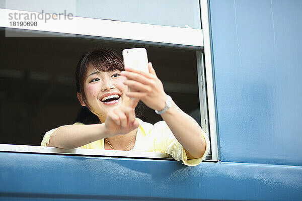 Japanerin fotografiert aus Zugfenster