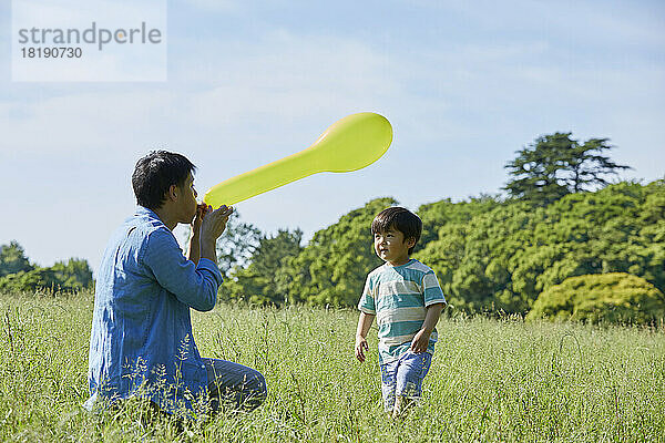 Japanische Eltern und Kinder spielen mit einem Ballon