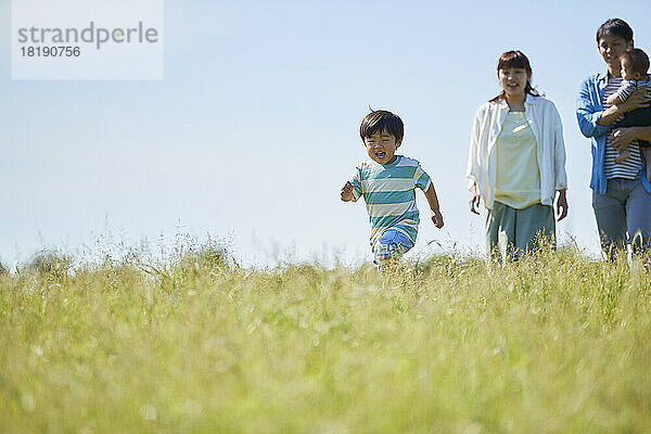 Japanische Familie mit einem Lächeln und blauem Himmel im Hintergrund