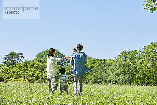 Japanische Familie geht auf dem Feld spazieren