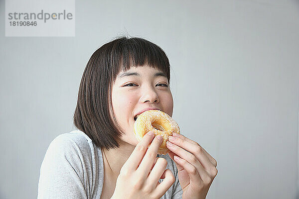 Junge Japanerin isst einen Donut