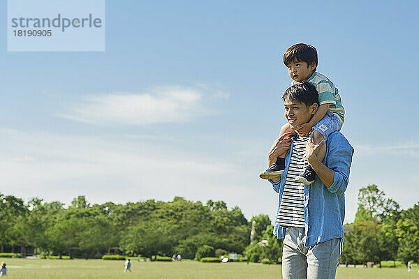 Japanischer Vater trägt seinen Sohn auf seinen Schultern