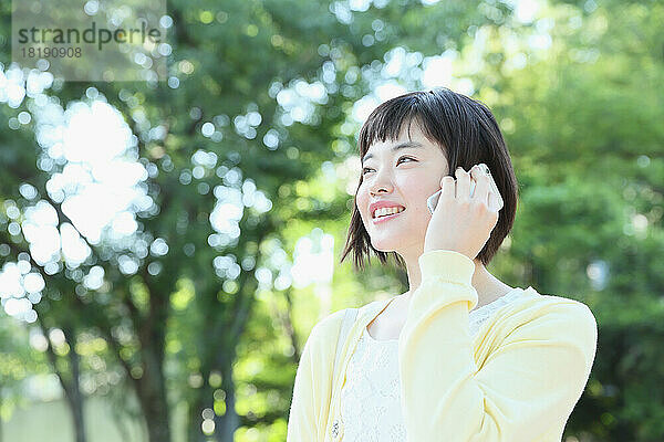Junge Japanerin telefoniert mit einem Mobiltelefon