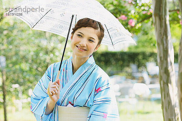 Japanerin in einem Yukata mit Sonnenschirm