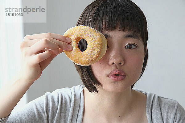 Junge Japanerin hält einen Donut