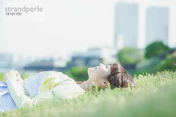 Japanerin entspannt sich im Gras
