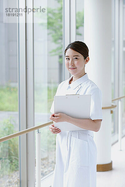 Junge japanische Krankenschwester im Flur