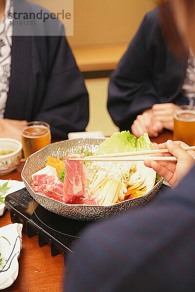 Japanische Frau beim Abendessen in einem Gasthaus mit heißen Quellen