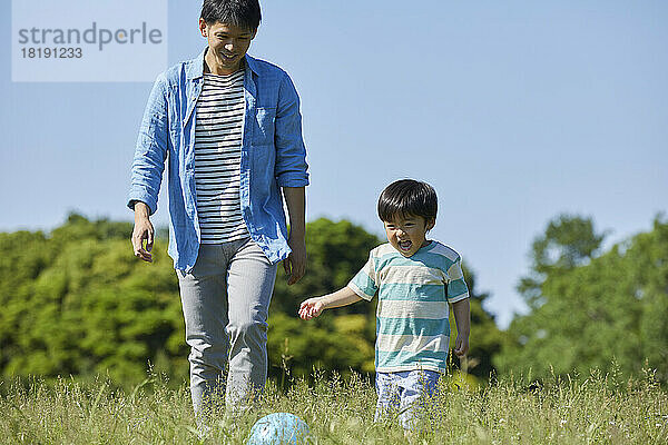 Japanische Eltern und Kinder spielen mit einem Ball
