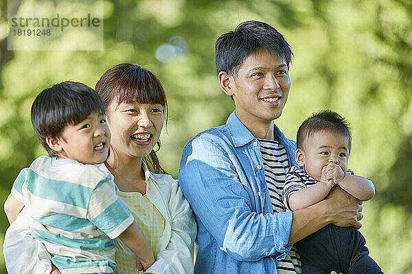 Frisches Grün und lächelnde japanische Familie