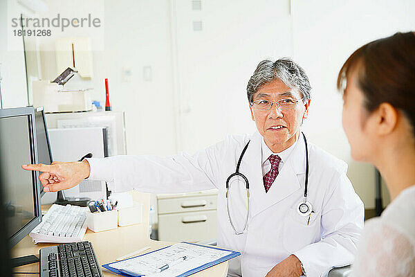 Patient wird von einem japanischen Arzt in einer Arztpraxis untersucht