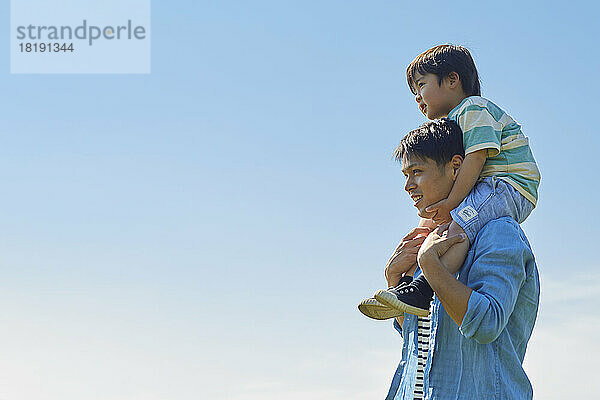 Japanischer Vater trägt seinen Sohn auf seinen Schultern