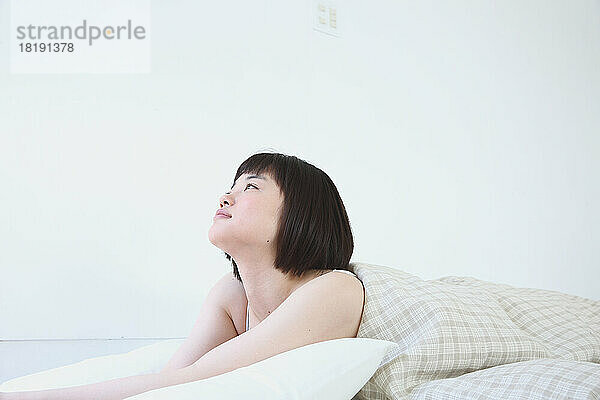 Junge Japanerin entspannt sich auf dem Bett