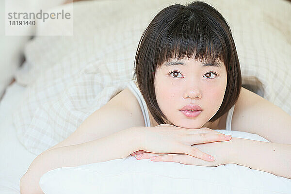 Junge Japanerin entspannt sich im Bett