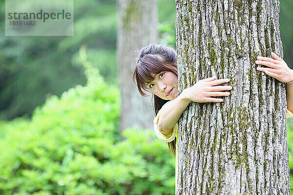 Japanerin umarmt einen Baum